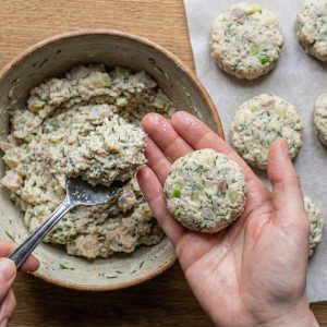 Using a large spoon to scoop a heaped tablespoon of Fiskefrikadeller mixture and shaping it into a roundish, 1-inch thick patty.
