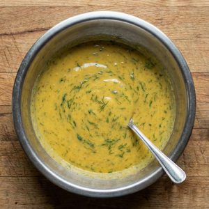 Finished Swedish hovmästarsås (mustard-dill sauce) in a mixing bowl, ready to chill before serving.
