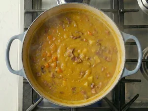 Thick Nordic pea soup finished in a Dutch oven with ham and vegetables
