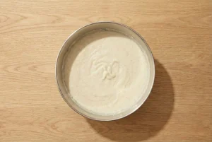 Ugnspannkaka batter after whisking in eggs, milk, and vanilla until smooth and pourable.