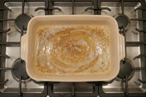 Butter melting and bubbling in a hot baking dish before adding ugnspannkaka batter.