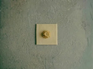 A tablespoon of remonce filling placed in the center of a 4x4 inch Danish pastry dough square before shaping