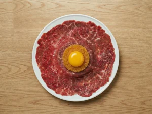 Raw egg yolk placed on top of löjrom and paper-thin beef tenderloin on toast for Toast Pelle Janzon assembly
