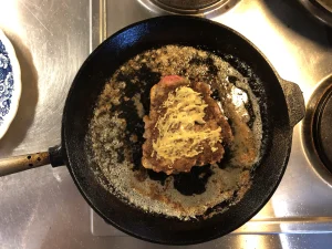 Dijon mustard spread over the cooked beef patty of a Swedish Opera Sandwich.