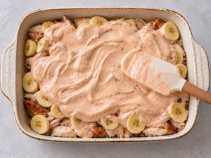 Creamy chili sauce spread over chicken and bananas in a Flying Jacob casserole